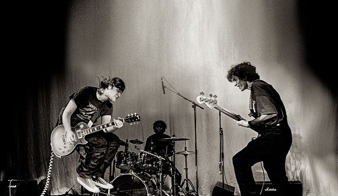 basement-door-youth-band-live-performance Youth band performing live on stage in black and white, capturing the energy and spirit of The Basement Door music program.