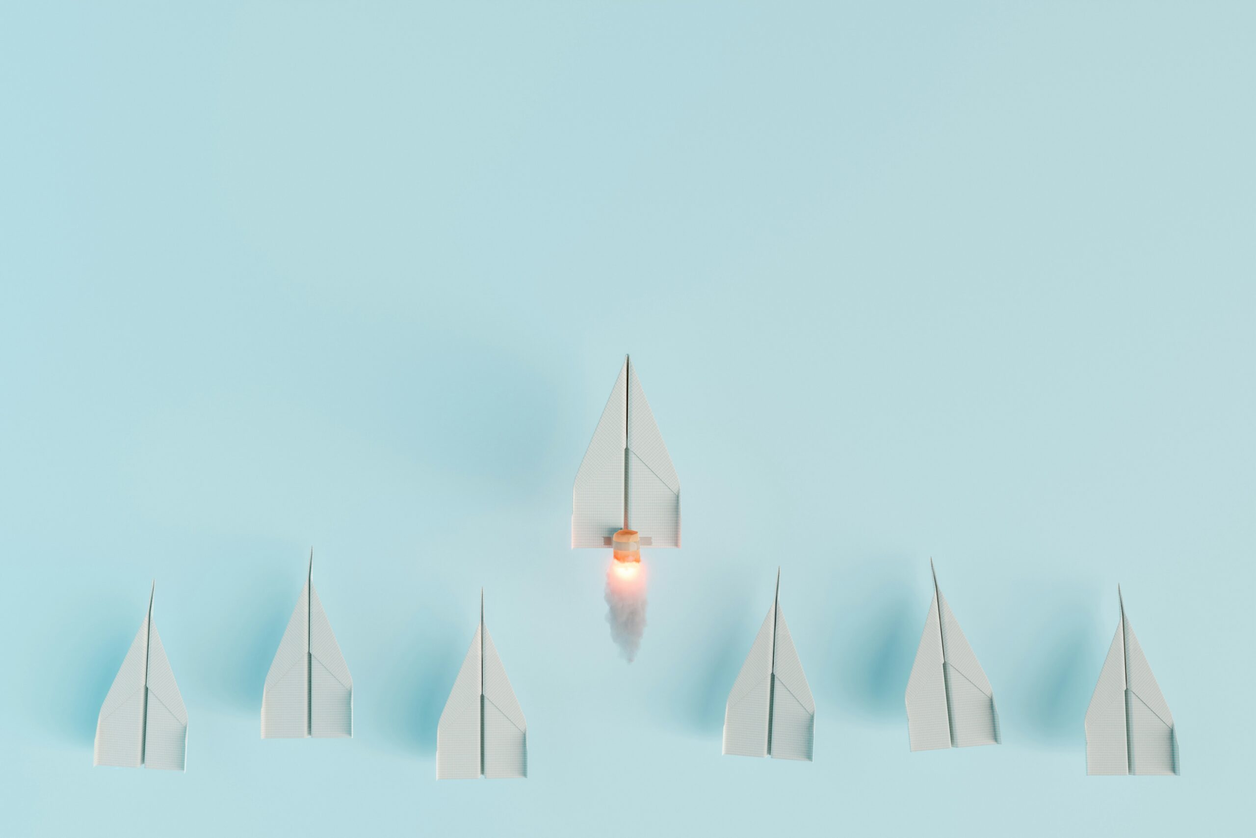 Chapter-based nonprofit org challenges and solutions 7 paper airplanes, one of which has rocket thrusters and flies above the rest